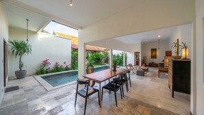 Un espace intérieur spacieux comprenant une table à manger, des chaises, une cheminée et une piscine.