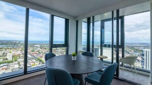 Ein Konferenzraum mit großem Tisch und Stühlen, großen Fenstern mit Blick auf die Stadt und einer kleinen Pflanze auf dem Tisch.