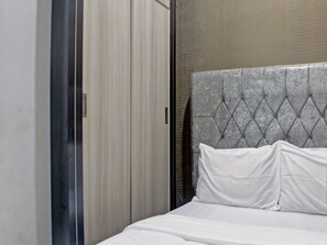 A bedroom with a bed, a grey headboard, and a sliding door. - OYO Life 92830 Homestay Slamet Riadi Iv (Bandar Lampung)