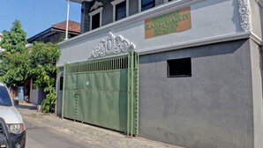 A building with a gated entrance, a sign for 'Homestay AMETRIADI TV', and a clear sky in the background. - OYO Life 92830 Homestay Slamet Riadi Iv (Bandar Lampung)