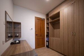 Un pasillo con un armario de madera, un espejo y una pequeña mesa con mantel a cuadros.