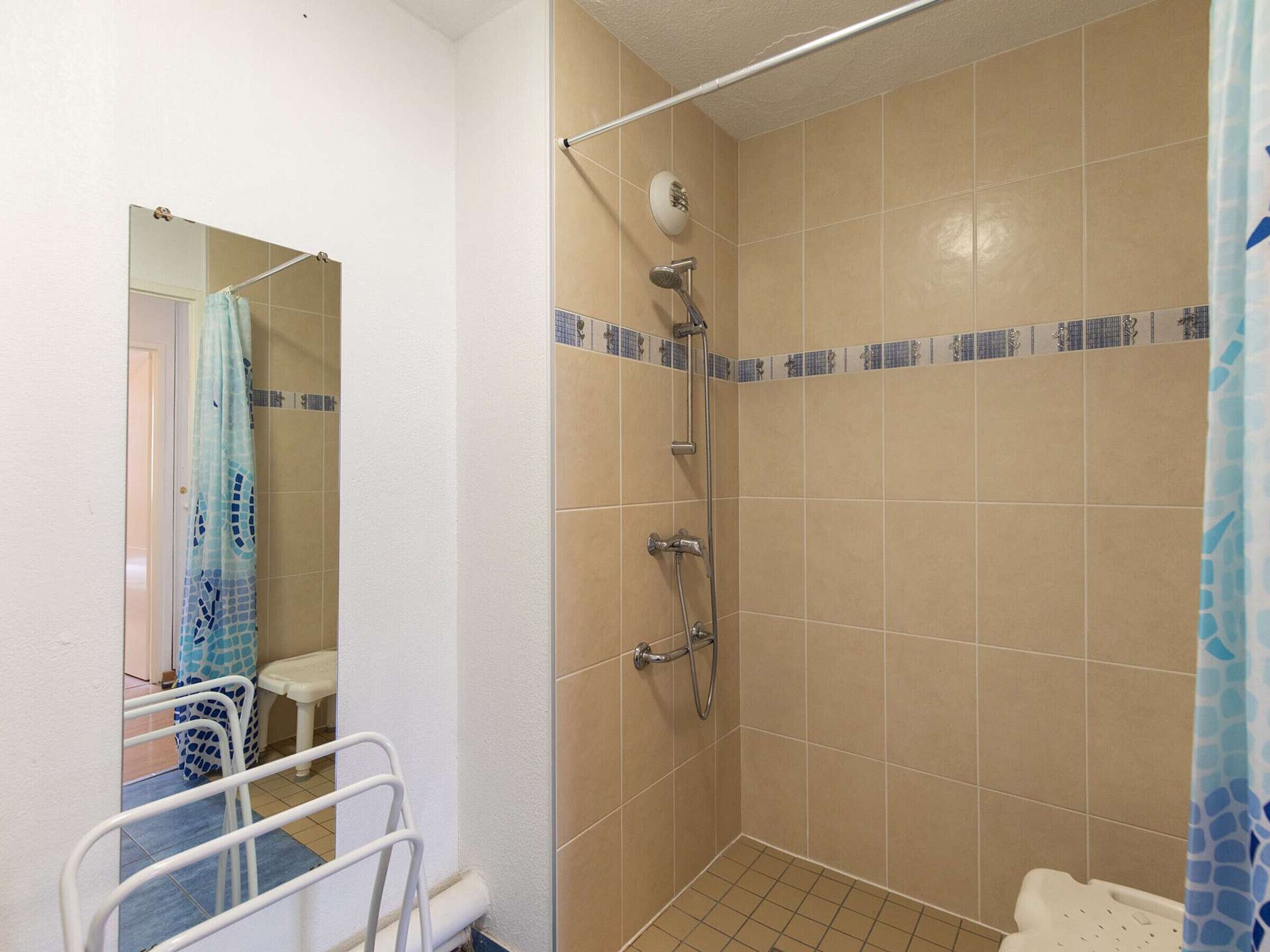 A small, tiled bathroom with a shower, a toilet, and a sink.