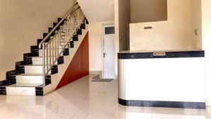A reception area with a marble staircase and a reception desk. - OYO Life 92707 D-akomiba Residence (Jambi)