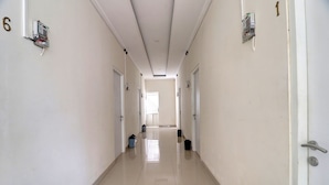 A long, narrow hallway with doors numbered 1 and 6, leading to rooms. - OYO Life 92707 D-akomiba Residence (Jambi)