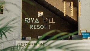 A reception area with a sign for Riva Hill Resort.