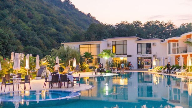 Hotel amb piscina, recepció i botiga.