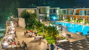 Un hotel amb piscina, zona de menjador exterior i restaurant.