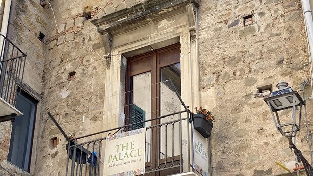 A building facade with a sign reading "The Palace B&B and Apartments".