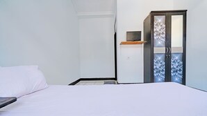 Une chambre à coucher avec un lit, une armoire et une petite étagère.