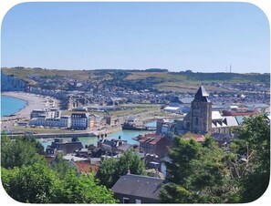 A coastal town with a prominent church, a river, and a beach.
