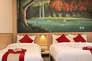 A hotel room with two beds, red pillows, a painting of a waterfall, and a view of boats on a lake. - Hotel Malati (Kathmandu)