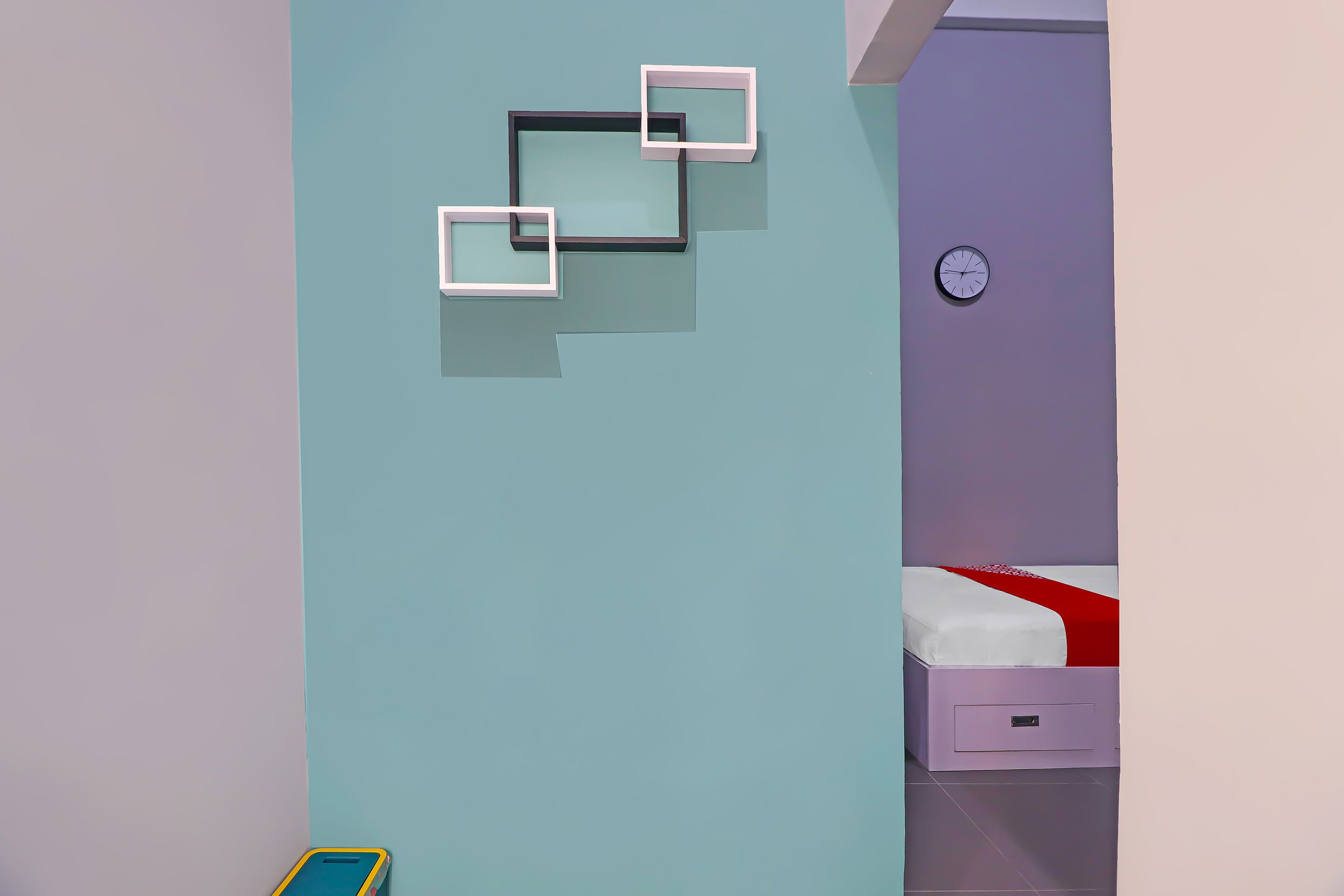 Une chambre à coucher avec un lit, une table de chevet et une horloge fixée au mur.