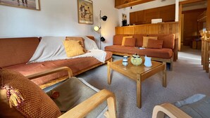 Ein gemütliches Wohnzimmer mit einer Couch, einem Holztisch und einem Bücherregal.