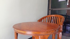 A round wooden table with a matching chair. - OYO Life 92915 Duta Amnan Syariah (Sidoarjo)