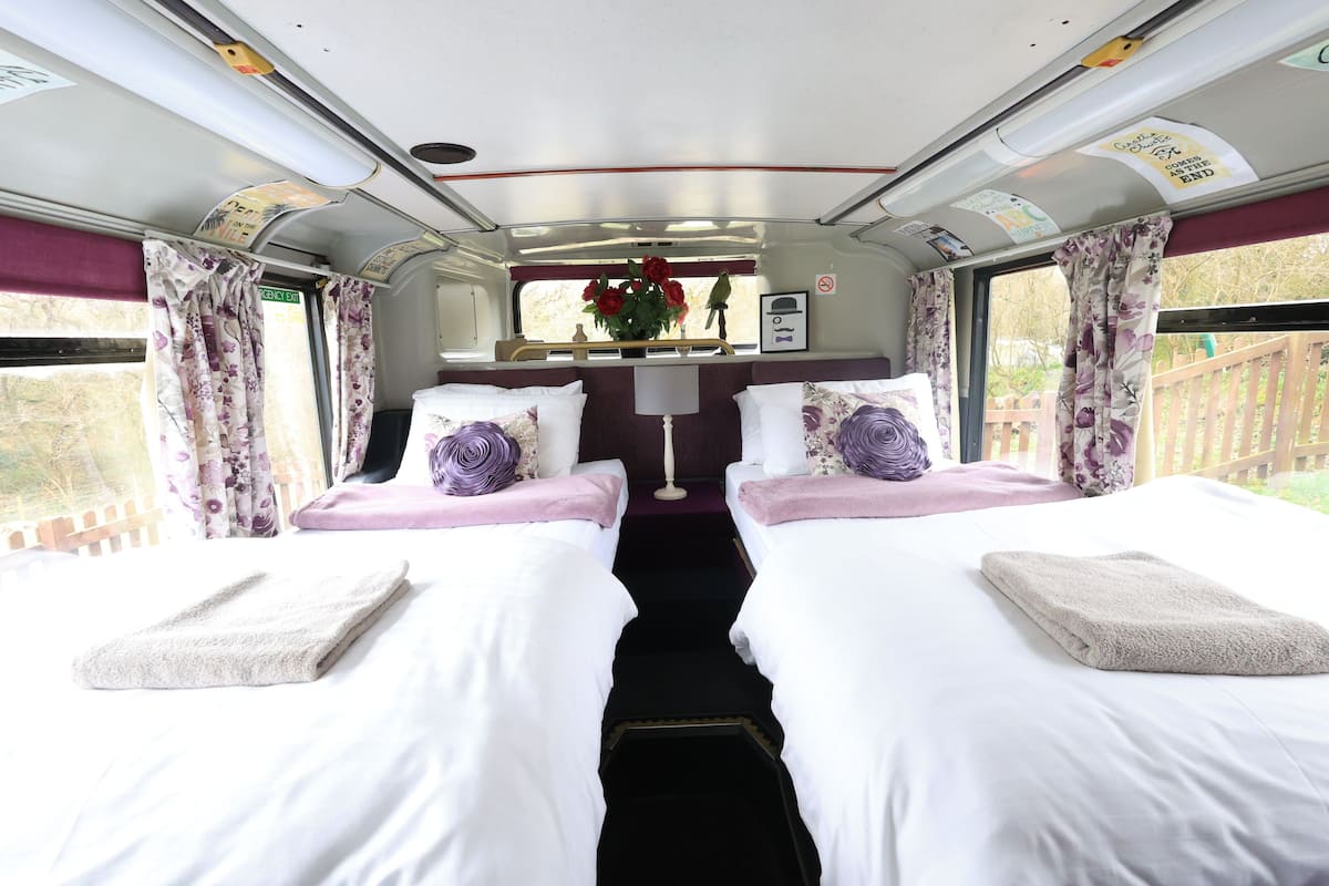 A train compartment with two beds, each with a pillow and a folded towel.