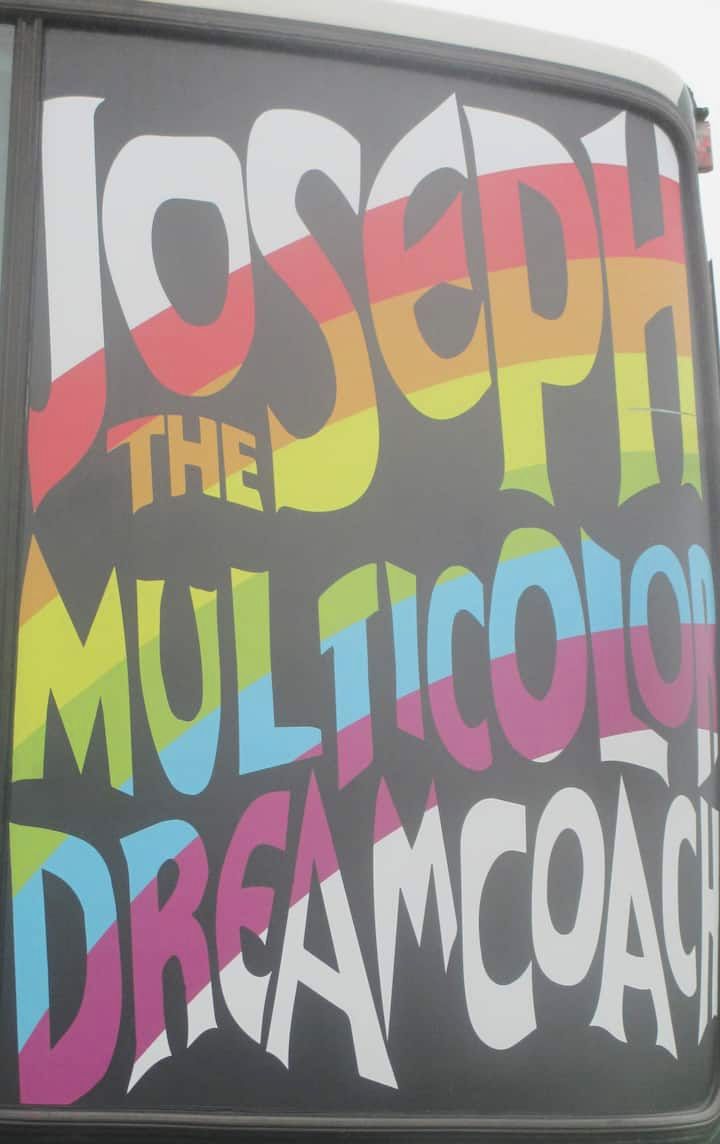 A vehicle with the text 'JOSEPH THE MULTICOLOR DREAMCOACH' on its side.