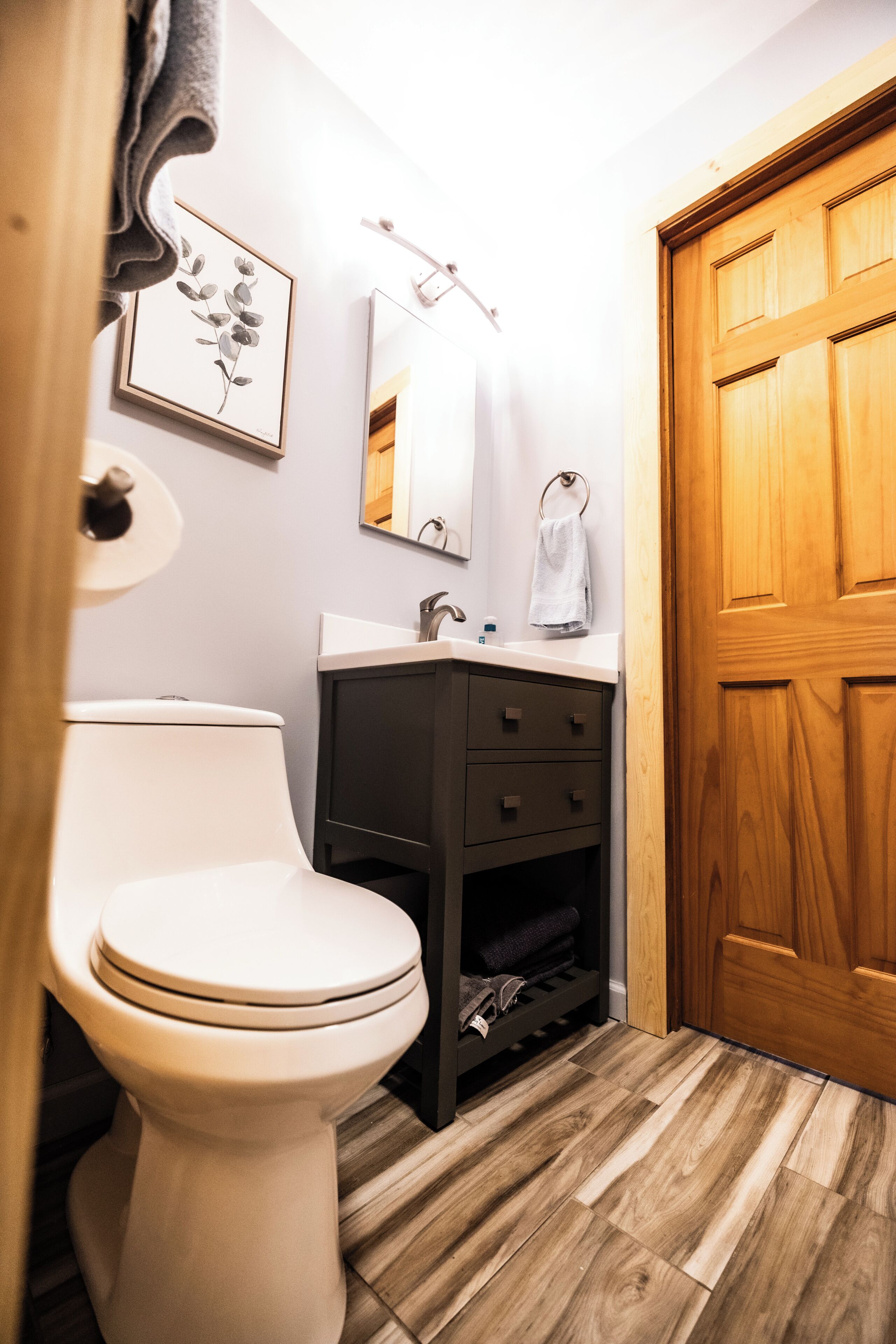 Een badkamer met toilet, wastafel en een houten kastje.