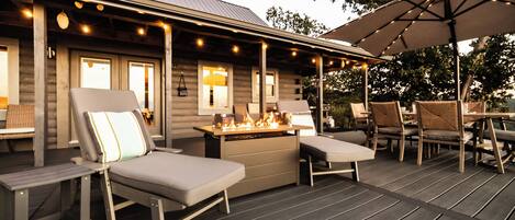 A covered outdoor seating area with lounge chairs and a bar.