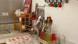 Een keuken met een gasfornuis, een magnetron en diverse keukengerei en pannen.