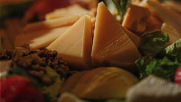 A cheese platter with various types of cheese, nuts, and greens.
