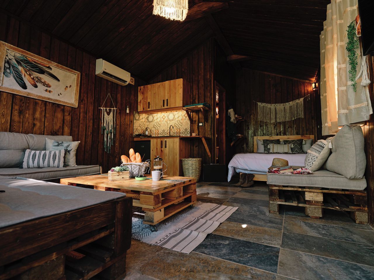 Ein rustikales Blockhaus-Interieur mit Holztisch, einer Couch und einem Bett mit Baldachin.