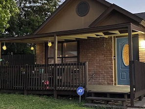 A building with a porch, a blue door, and a sign indicating ADA accessibility.