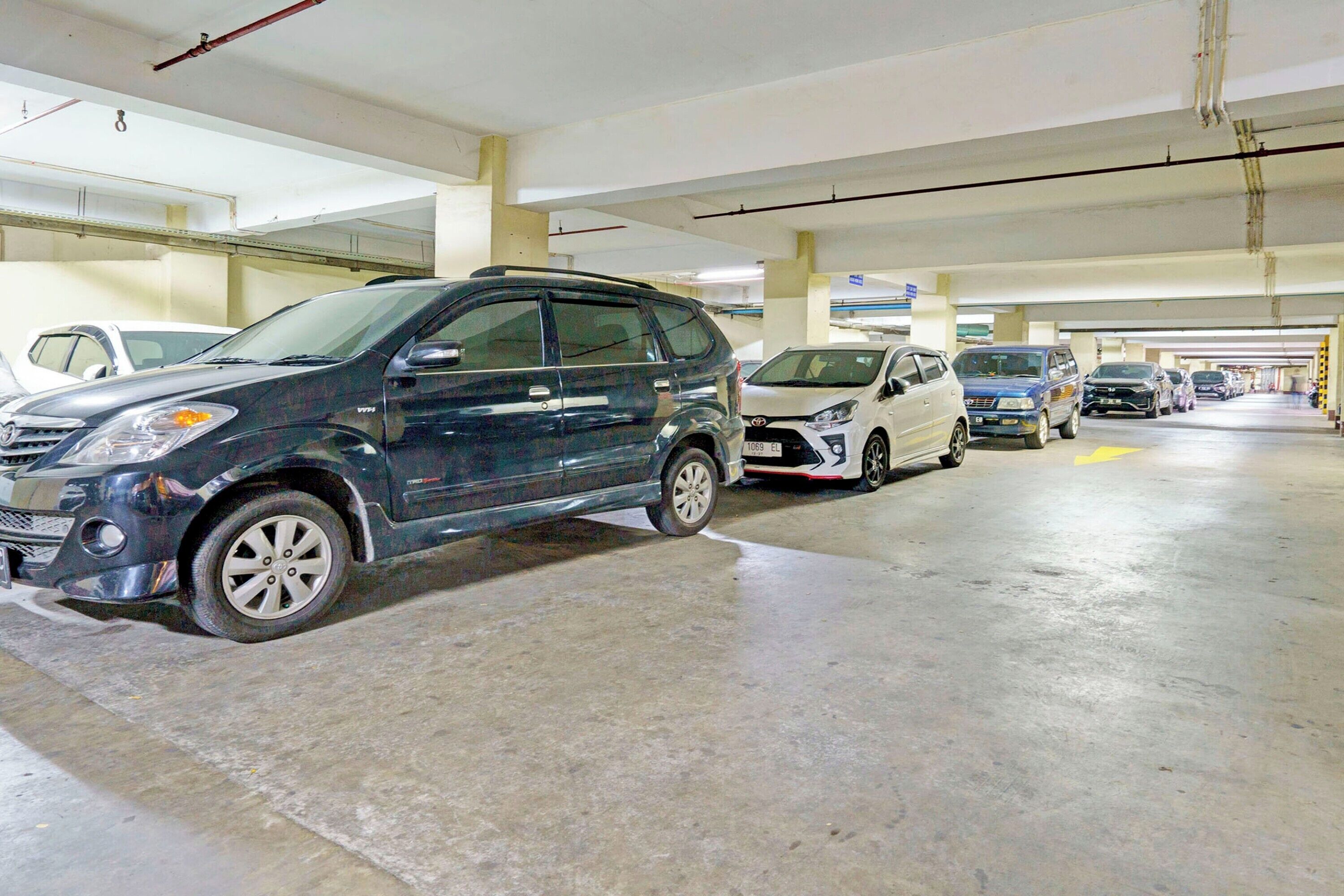 Un parking à plusieurs niveaux où sont stationnés différents types de véhicules.