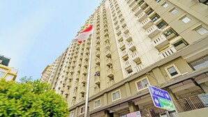 Un edificio de gran altura con varios balcones y una bandera en la cima.