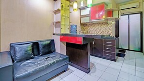 Cocina compacta con sofá, dispensador de agua y refrigerador.