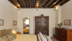 A bedroom with a bed, a dresser, a mirror, and a nightstand. - Amazing Fontana di Trevi (Roma)
