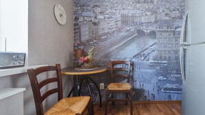A room with a view of a cityscape, a table with chairs, a clock, and a radio. - Luxurious apartment  in Minsk (Minsk)