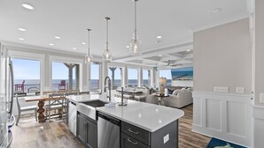 A modern kitchen with a large island, built-in appliances, and a view of the ocean. - Experience luxury at '7 Day Weekend,' an oceanfront 7-bedroom retreat in Oak Island. (Oak Island)