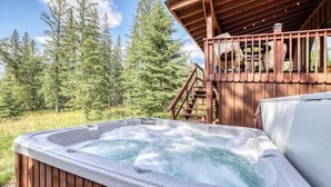 A hot tub in a wooden cabin surrounded by a forest.