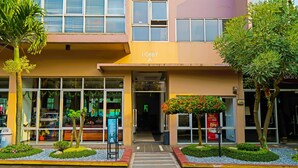 A building with a 'Lobby A' sign, a glass entrance, and a small garden area with plants and a pathway leading to the entrance. - OYO Life 92774 The Edge Apartment By My Home (Cimahi)