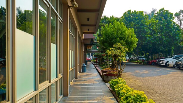 A building with large windows and a paved walkway. - OYO Life 92774 The Edge Apartment By My Home (Cimahi)