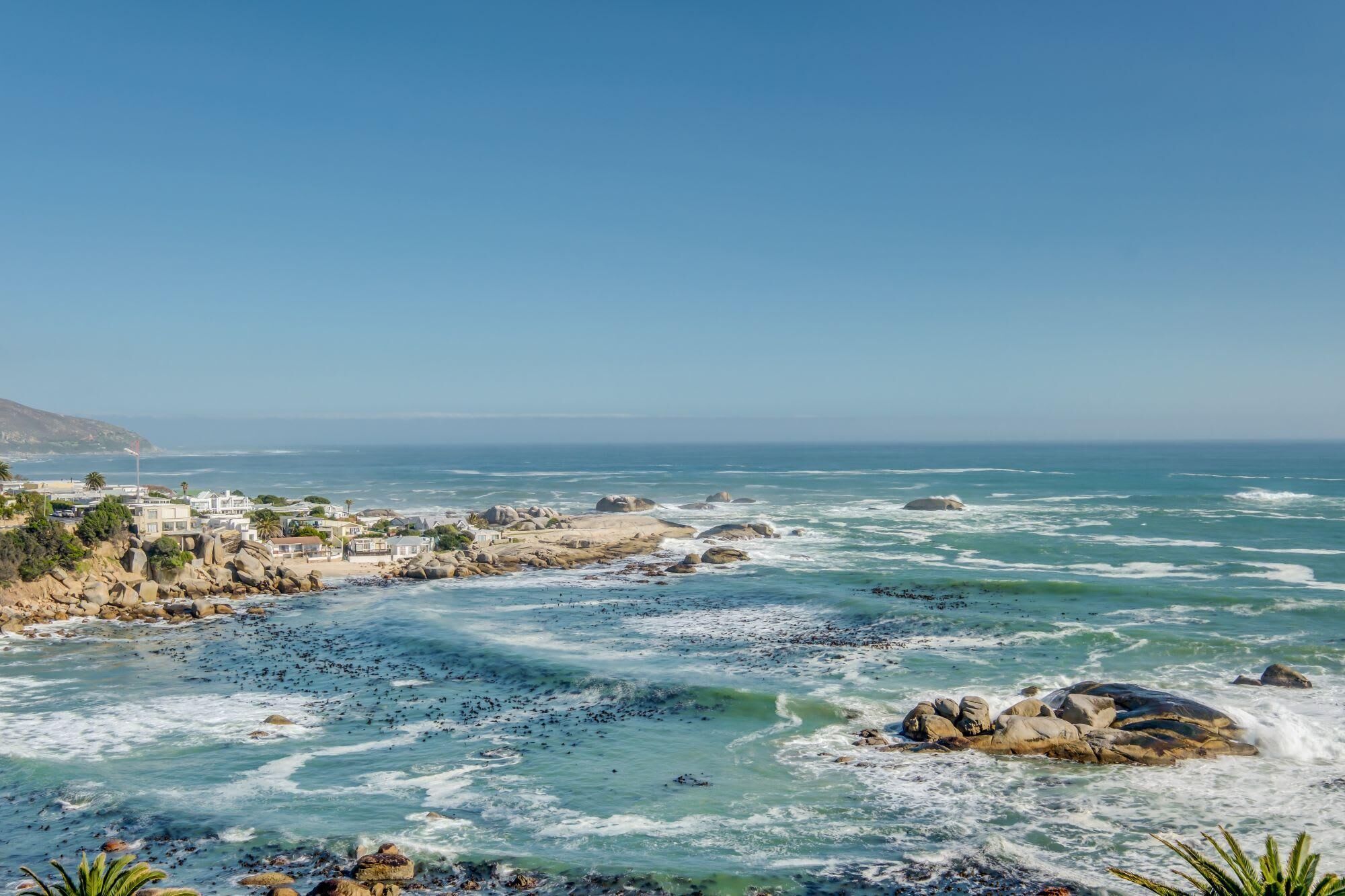 A coastal town with rocky shores and a clear view of the ocean.