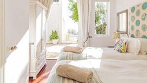 A bedroom with two beds, a window with curtains, a mirror, and a view of the outdoors. - Lovely Holiday Home w Private Courtyard Six Selbourne (Cape Town)