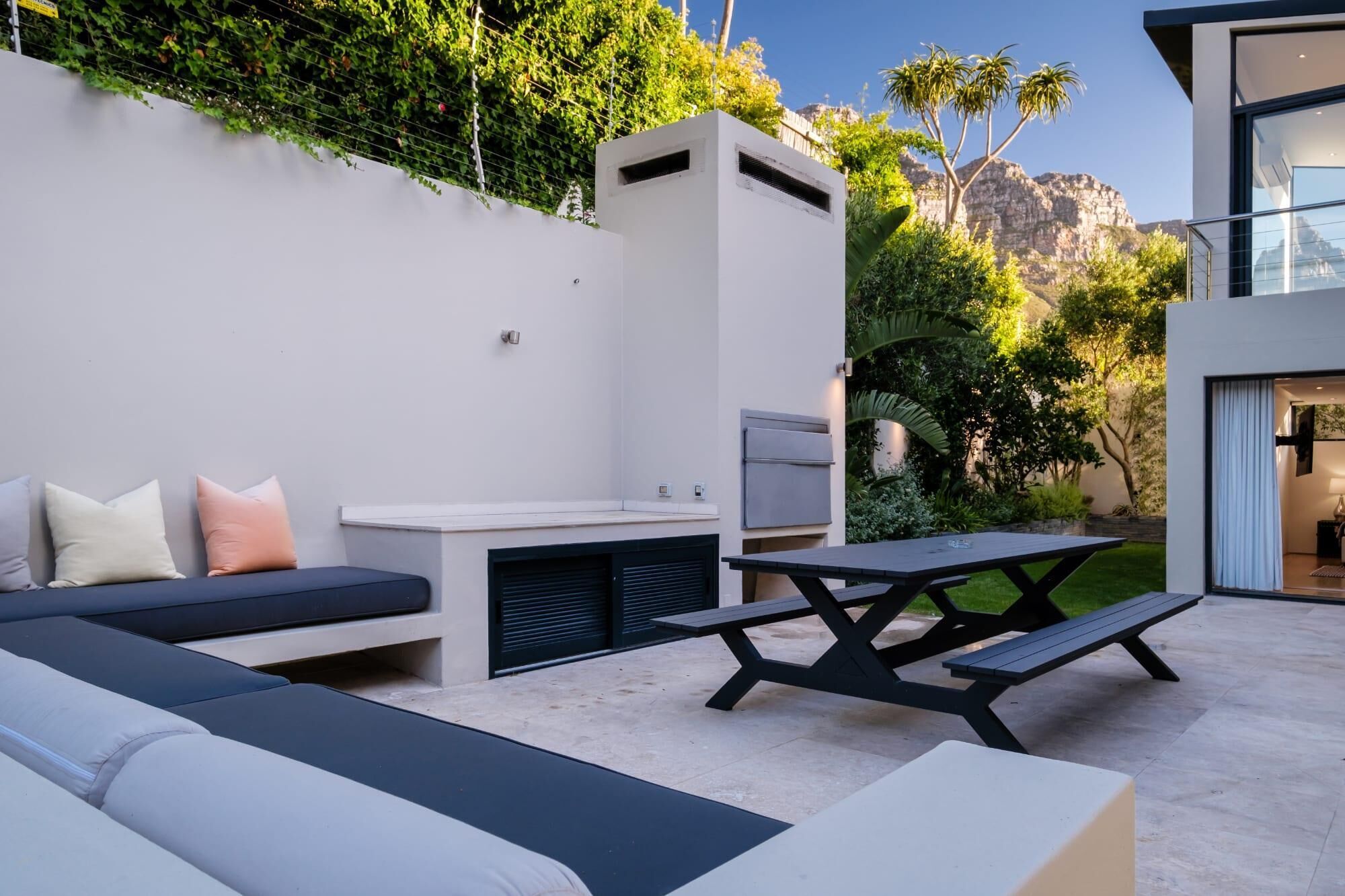 An outdoor patio with a sofa, a table, and a grill.