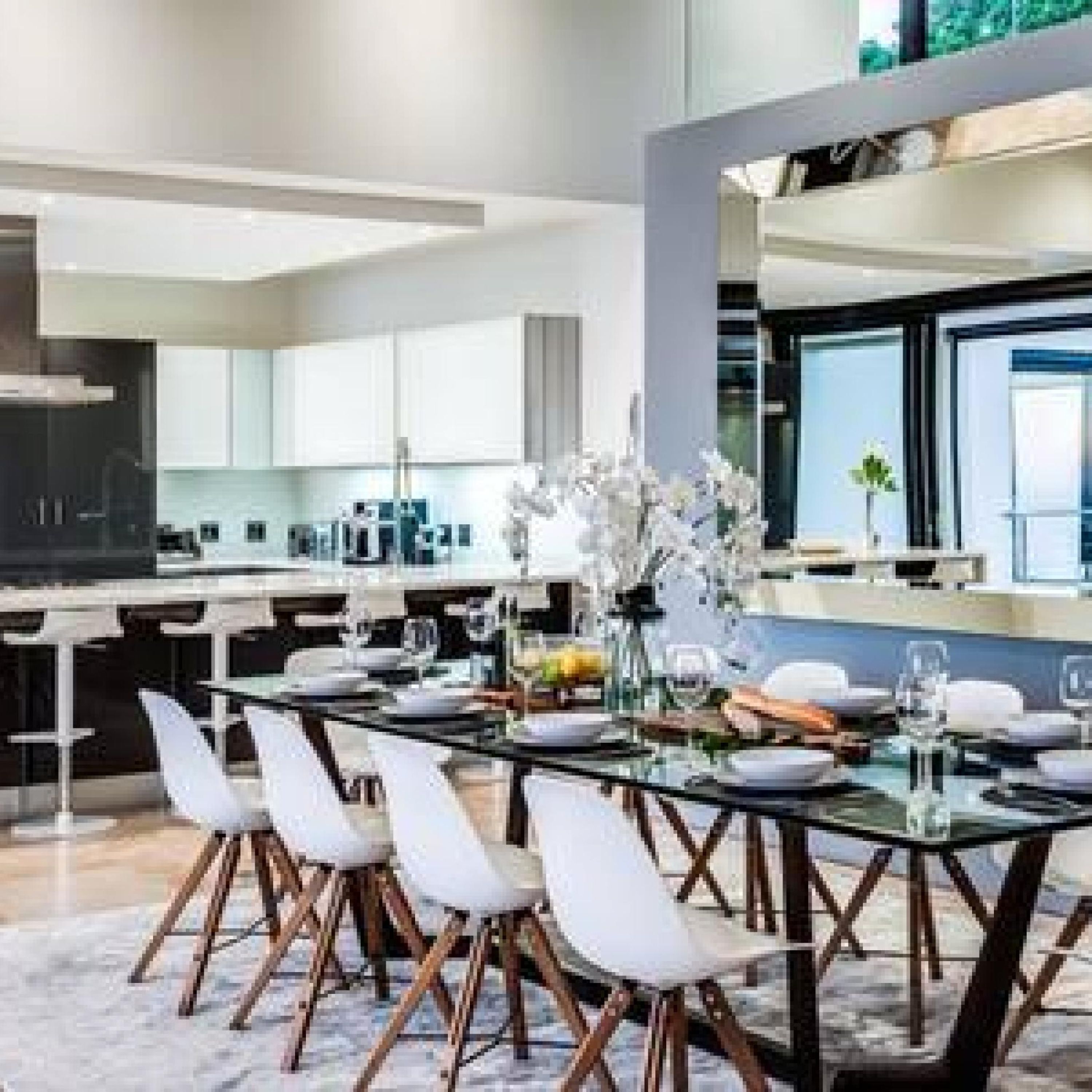 A modern kitchen with a large island, white cabinetry, and a view of the outdoors.