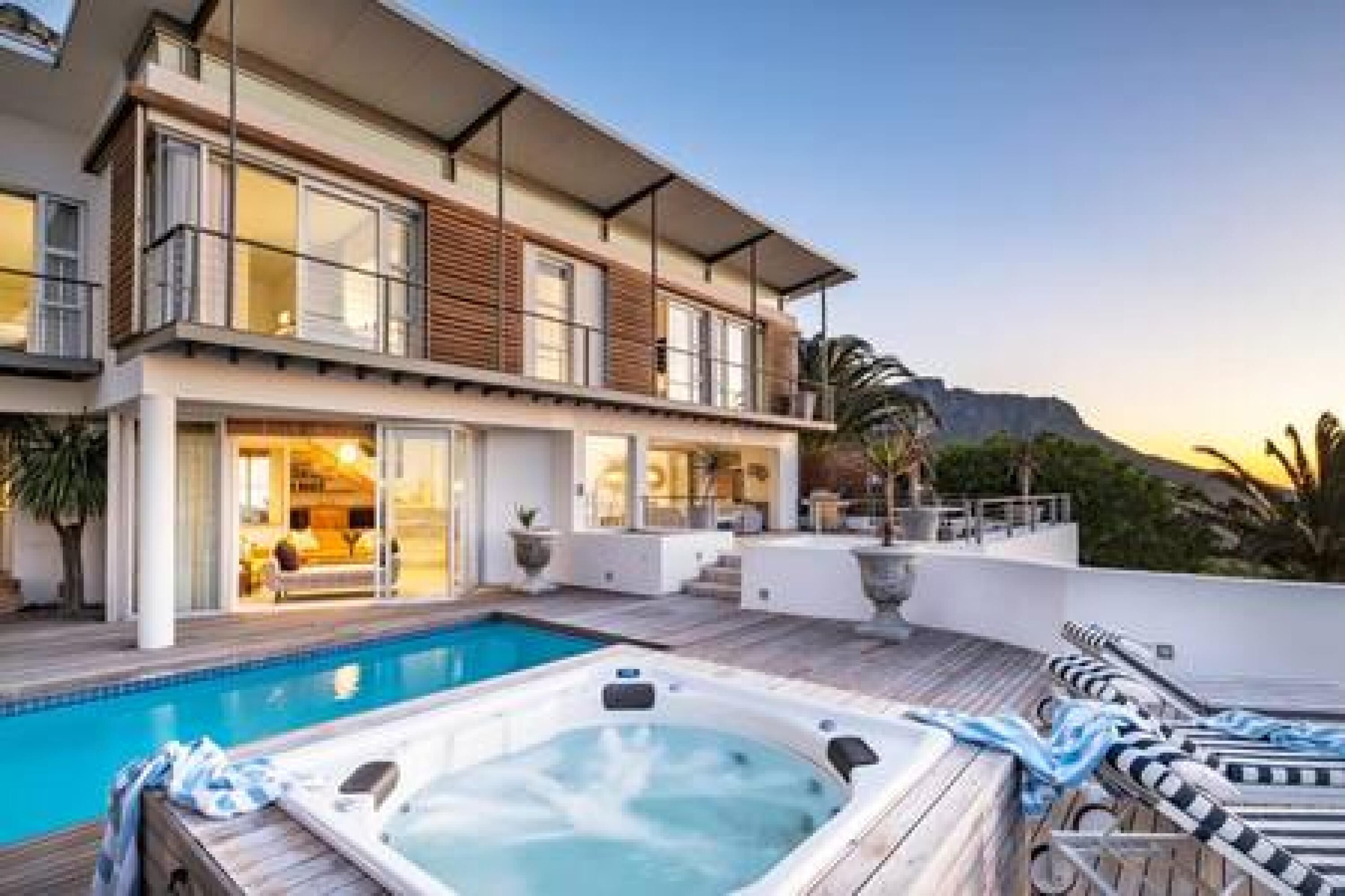 Una casa moderna a due piani con piscina e vasca idromassaggio.