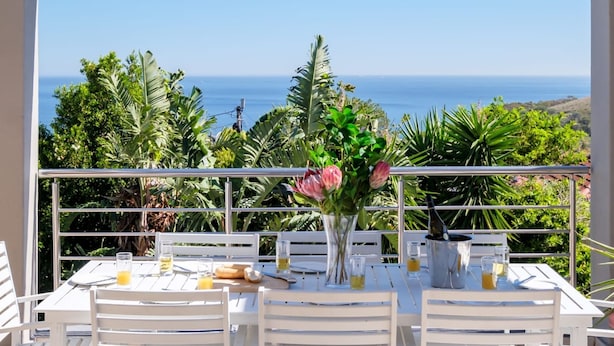 A table set for two with a view of the ocean. - Family Home With Views Pool Garden 100 Geneva (Cape Town)