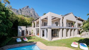 A modern two-story house with a swimming pool, a balcony, and a mountain view. - Family Home With Views Pool Garden 100 Geneva (Cape Town)