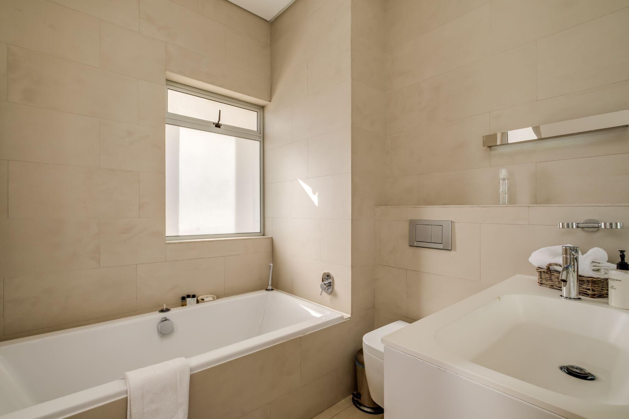 A modern bathroom with a bathtub, a toilet, and a sink.