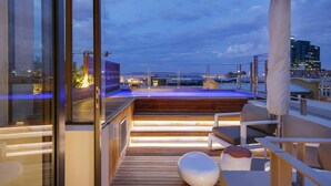 Une terrasse sur le toit avec une piscine, une plateforme en bois et un espace salon.