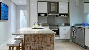 A modern kitchen with a central island, built-in appliances, and a clean, minimalist design.