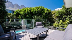A deck with outdoor furniture, a glass balustrade, and a view of mountains. - Spacious Holiday Villa w Private Pool Garden Serein (Cape Town)