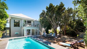 A modern house with a swimming pool, outdoor furniture, and a large tree. - Spacious Holiday Villa w Private Pool Garden Serein (Cape Town)