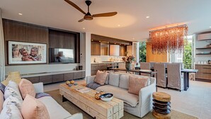 A modern living room with a sofa, coffee table, and a dining area with chairs. - Stylish Apartment With Rooftop Deck Pool 53 Napier (Cape Town)