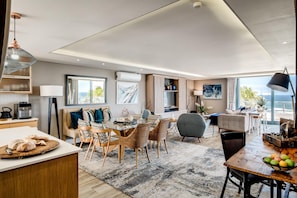 Un soggiorno moderno con zona pranzo, cucina e angolo salotto con vista.