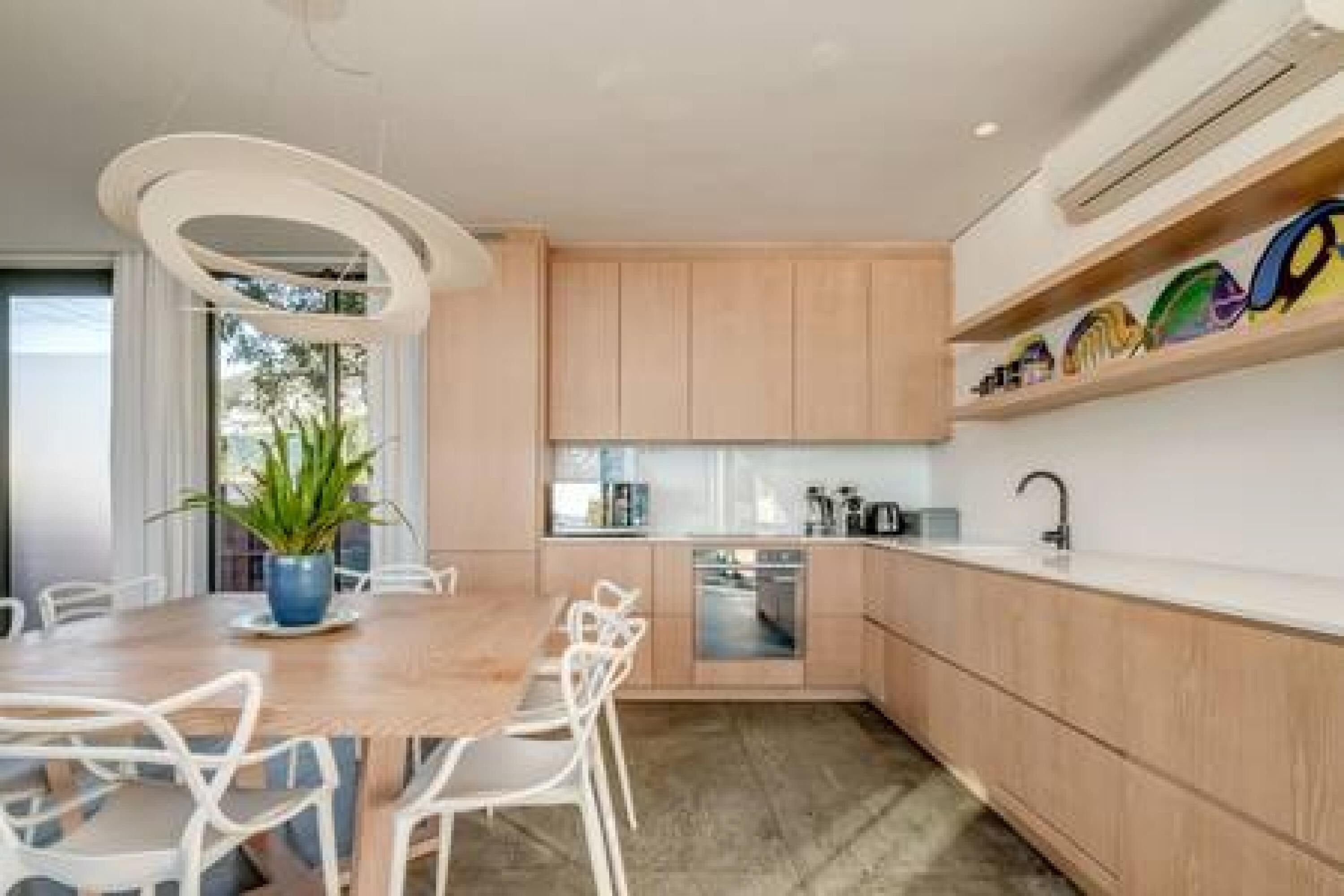 Una cocina moderna con armarios de madera, encimera blanca y lavavajillas integrado.